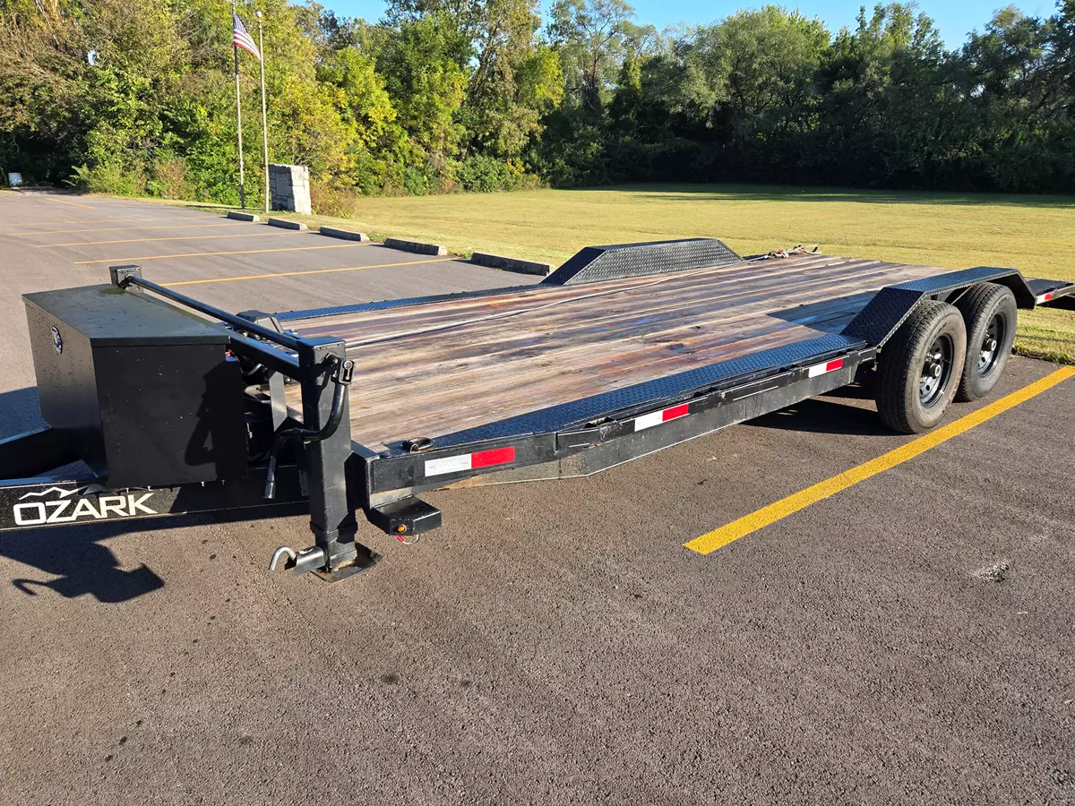 Equipment trailer with winch on a sunlit yard